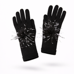 Black gloves with black and white pom-pom attachments on a white background