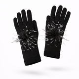 Black gloves with black and white pom-pom attachments on a white background