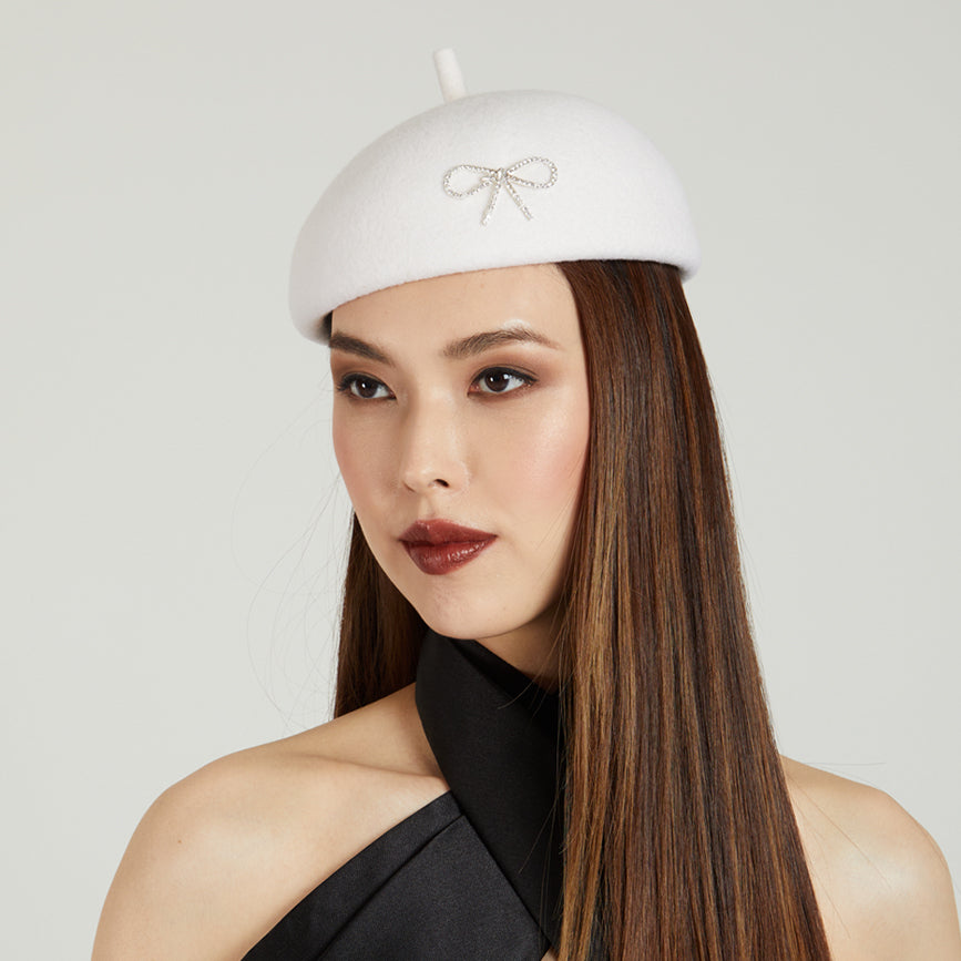 White beret with a decorative bow on model