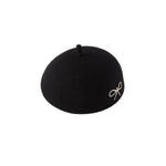 Black beret with a white bow on a white background