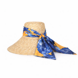 Straw hat with a blue and yellow floral scarf on a white background