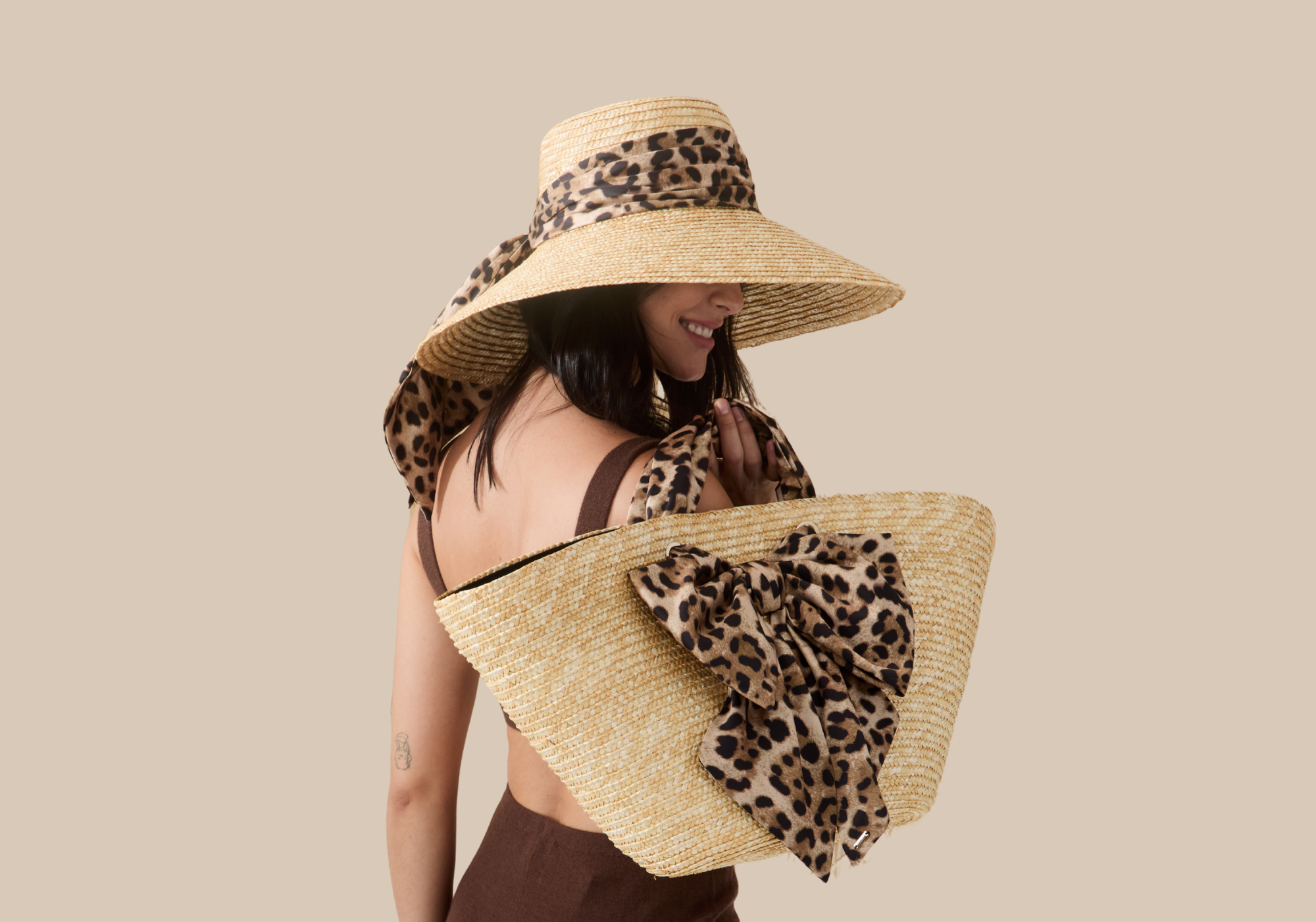 Model wearing leopard mirabel sun hat and leopard carlotta in leopard from Eugenia Kim Cruise 2026.