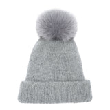 Eugenia Kim Maddox beanie in light gray — a luxurious knit winter hat featuring a soft faux fur pom-pom and warm ribbed texture. Perfect for chic, cold-weather style and everyday wear.